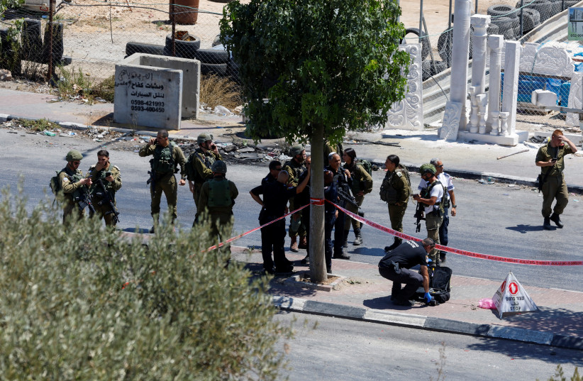  Israeli forces keep guard at the scene of what the Israeli military said is a ramming attack near Hebron, in the West Bank, August 30, 2023. (credit: REUTERS/MUSSA QAWASMA)