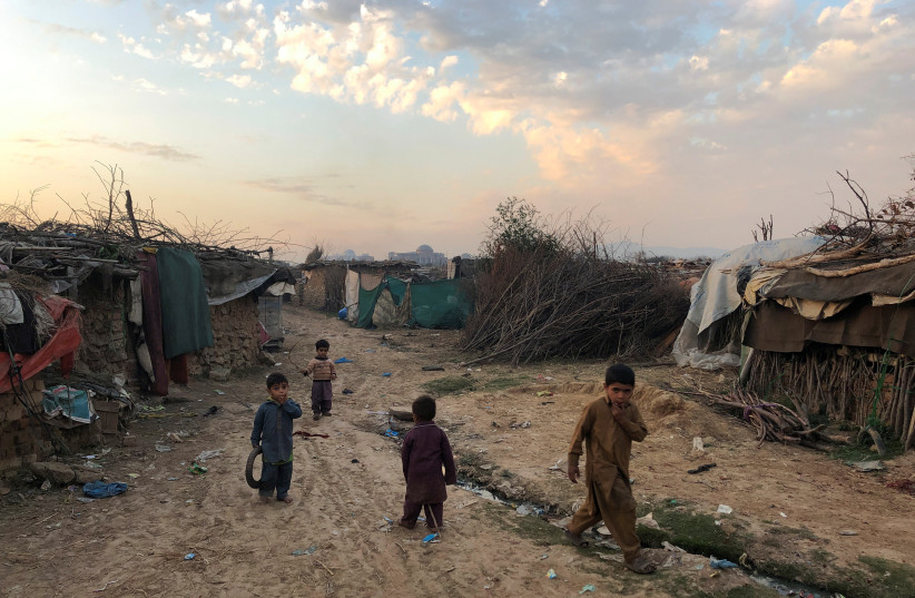  Children play outside their family's shelters at Afghan refugee camp in Islamabad, Pakistan February 13, 2020. Picture taken February 13, 2020. (credit: REUTERS/Charlotte Greenfield)