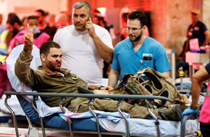  An injured Israeli officer gestures as he arrives at a hospital, following a mass-infiltration by Hamas gunmen from the Gaza Strip, in Ashkelon, southern Israel (credit: AMIR COHEN/REUTERS)