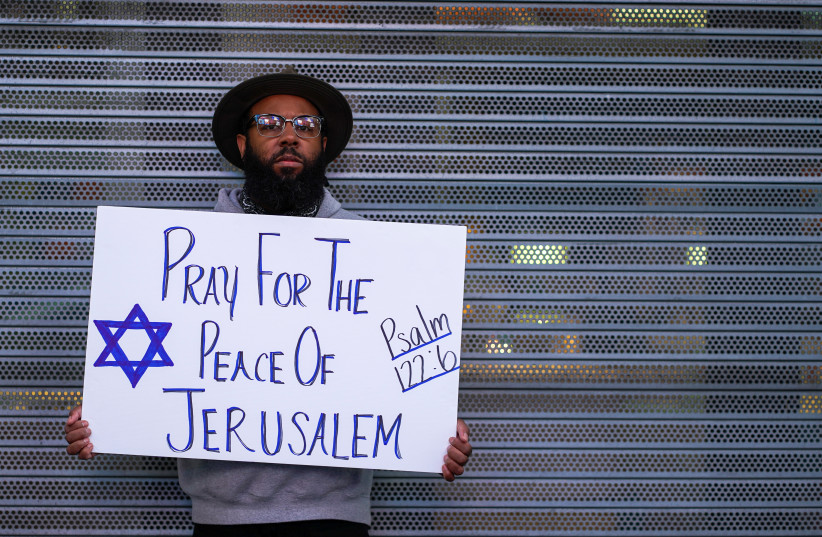  A person holds a sign that reads ''Pray for the Peace of Jerusalem'' at a Pro-Israel rally at Times Square in New York City, U.S., May 12, 2021 (credit: REUTERS/DAVID 'DEE' DELGADO)