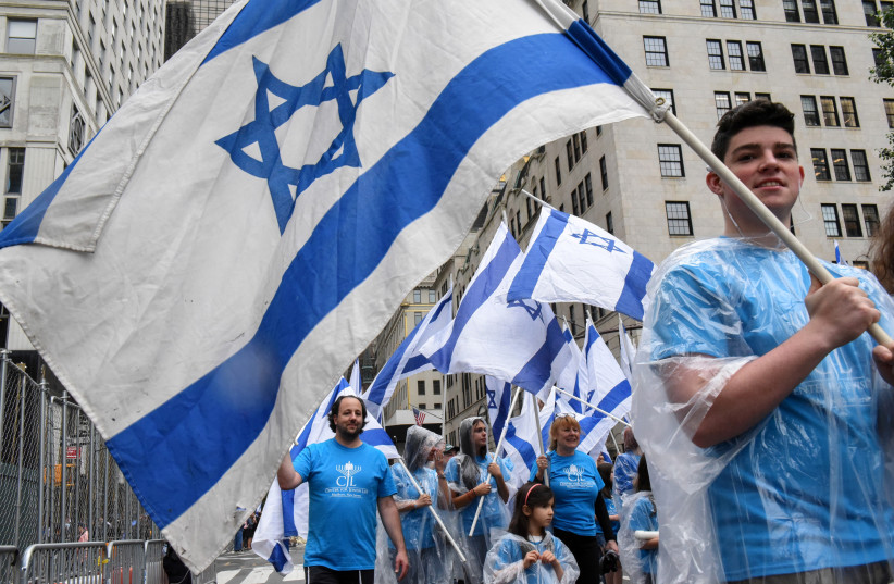  People carry Israeli flags while participating in the ''Celebrate Israel'' parade along 5th Ave. in New York City (credit: REUTERS)