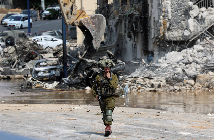 Израильский солдат патрулирует возле полицейского участка, который стал местом боя после массового проникновения боевиков ХАМАС из сектора Газа, в Сдероте, на юге Израиля, 8 октября 2023 г. (Фото: REUTERS/Ronen Zvulun)