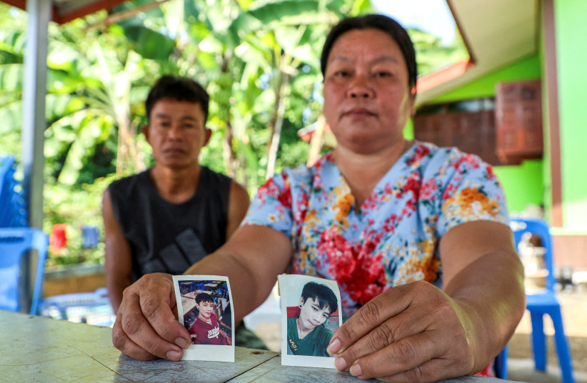  The parents of a 26-year-old Thai man kidnapped by Hamas hold up his photo. (credit: REUTERS/THOMAS SUEN/FILE PHOTO)