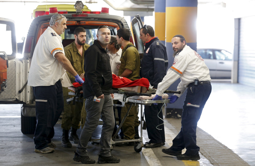  An Israeli, one of three wounded in what an Israeli military spokesperson said was a shooting attack at an Israeli military checkpoint in the West Bank, is evacuated to a hospital in Jerusalem January 31, 2016. (credit: REUTERS/AMIR COHEN)