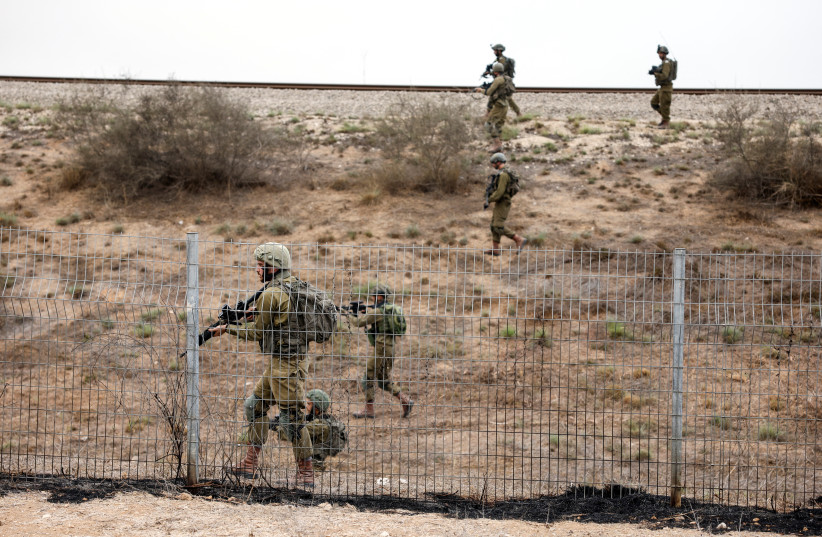  Israeli soldiers scan an area while sirens sound as rockets from Gaza are launched towards Israel, near Sderot, southern Israel, October 9, 2023 (credit: REUTERS/AMIR COHEN)