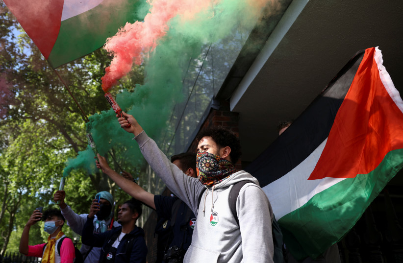  A protester carries a smoke flare during a pro-Palestine demonstration near Israel's Embassy in London, Britain, May 23, 2021 (credit: REUTERS/HENRY NICHOLLS)