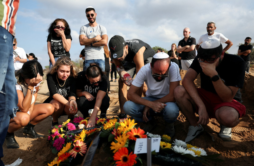  People mourn at the graveside of Eden Guez, who was killed as she attended a festival that was attacked by Hamas gunmen from Gaza that left at least 260 people dead, at her funeral in Ashkelon, in southern Israel, October 10, 2023. (credit: REUTERS/VIOLETA SANTOS MOURA)