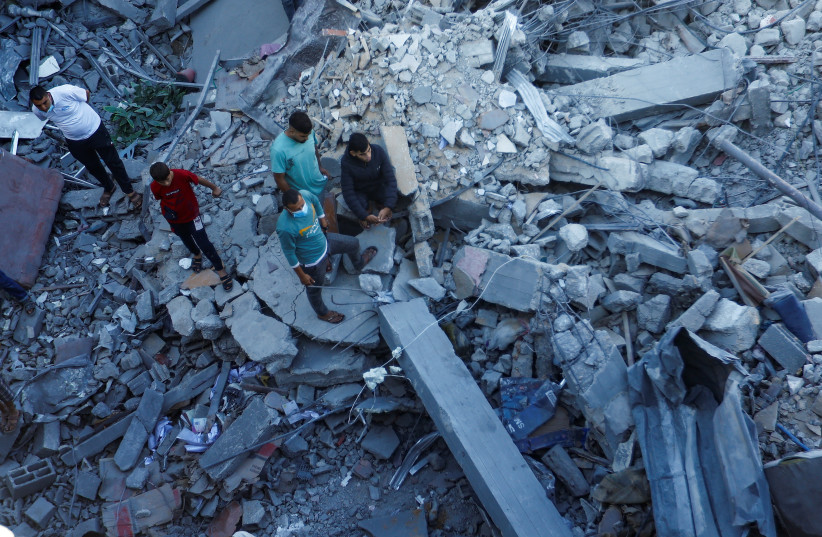 Palestinians search for casualties under the rubble in the aftermath of Israeli strikes amid the ongoing conflict between Israel and the Palestinian Islamist group Hamas, in Khan Younis in the southern Gaza Strip October 13, 2023.