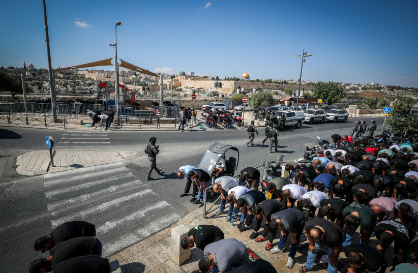  Israeli police guard while Palestinians perform Friday prayers in the East Jerusalem  Neighborhood of Ras Al Amud, October 13, 2023. (credit: JAMAL AWAD/FLASH90)