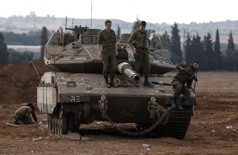  Israeli soldiers stand atop an Israeli tank near Israel's border with the Gaza Strip, in southern Israel October 15, 2023. (credit: REUTERS/AMIR COHEN)