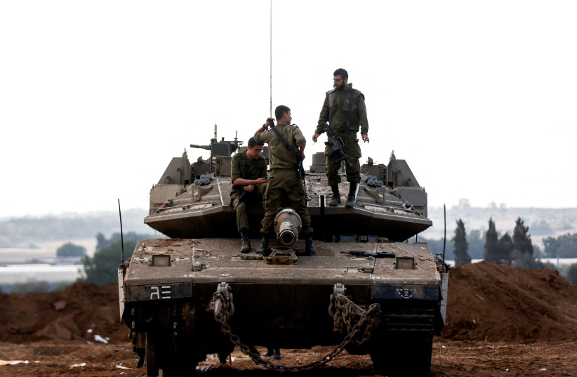  Israeli soldiers stand atop an Israeli tank near Israel's border with the Gaza Strip, in southern Israel October 15, 2023. (credit: REUTERS/AMIR COHEN)