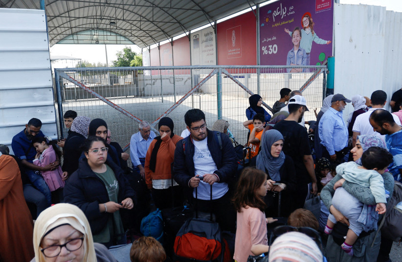  Palestinians with dual citizenship gather outside Rafah border crossing with Egypt in the hope of getting permission to leave Gaza, amid the ongoing Israeli-Palestinian conflict, in Rafah in the southern Gaza Strip. October 14, 2023. (credit: IBRAHEEM ABU MUSTAFA/REUTERS)