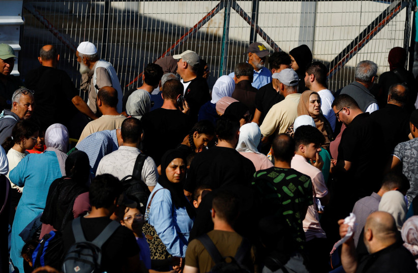 Palestinians with dual citizenship gather outside Rafah border crossing with Egypt in the hope of getting permission to leave Gaza, amid the ongoing Israeli-Palestinian conflict, in Rafah in the southern Gaza Strip October 16, 2023 (credit: REUTERS/IBRAHEEM ABU MUSTAFA)