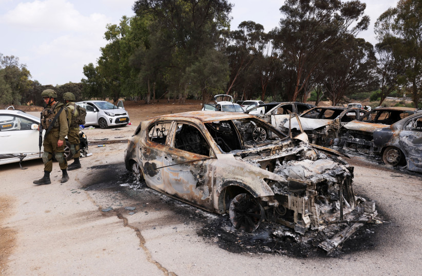  Israeli soldiers inspect burnt cars that are abandoned in a carpark near where a festival was held before an attack by Hamas gunmen from Gaza that left at least 260 people dead, by Israel's border with Gaza in southern Israel, October 10, 2023. (credit: REUTERS/Ronen Zvulun)