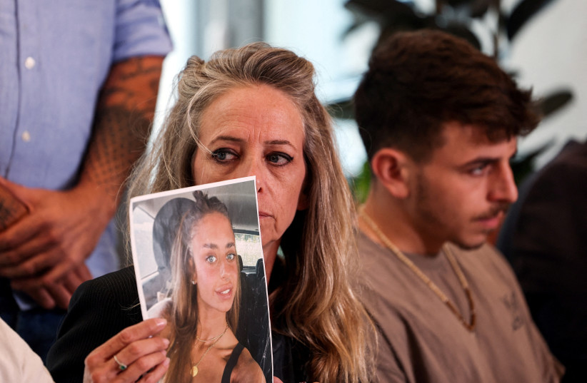  The mother of Mia Schem holds up a picture of her daughter who was kidnapped into the Gaza Strip, following a deadly infiltration by Hamas gunmen from Gaza, in Tel Aviv, Israel, October 17, 2023. Hamas has released a video of Schem. (credit: REUTERS/Ronen Zvulun)