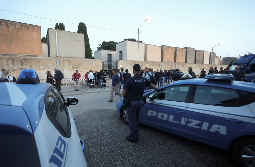 Police and media stand outside the cemetery waiting for the hearse carrying the body of late mafia boss Matteo Messina Denaro in the Sicilian town of Castelvetrano, Italy, September 27, 2023. (credit: REUTERS/Igor Petyx)