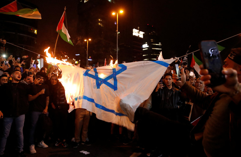  Demonstrators set fire to a makeshift Israeli flag during a protest, after hundreds of Palestinians were killed in a blast at Al-Ahli hospital in Gaza that Israeli and Palestinian officials blamed on each other, near the Israeli Consulate in Istanbul, Turkey October 18, 2023. (credit: REUTERS/DILARA SENKAYA)
