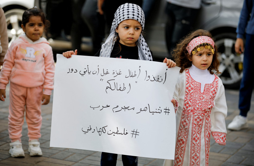 A child holds a placard as Palestinians take part in a protest in support of the people in Gaza, after hundreds of Palestinians were killed in a blast at Al-Ahli hospital in Gaza that Israeli and Palestinian officials blamed on each other, in Nablus in the West Bank October 18, 2023 (credit: RANEEN SAWAFTA/REUTERS)