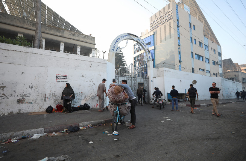  People are seen outside the area of Al-Ahli hospital where hundreds of Palestinians were killed in a blast that Israeli and Palestinian officials blamed on each other, and where Palestinians who fled their homes were sheltering amid the ongoing conflict with Israel, in Gaza City, October 18, 2023 (credit: REUTERS/MOHAMMED AL-MASRI)