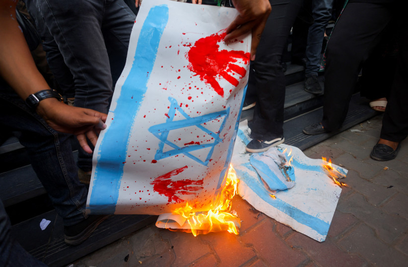  Demonstrators burn banners depicting the Israeli flag during a protest against Israel and the USA in support of Palestinians for those killed in a blast at Al-Ahli hospital in Gaza that Israeli and Palestinian officials blamed on each other, amid the ongoing conflict between Israel and Hamas, in Ca (credit: REUTERS/AMR ABDALLAH DALSH)