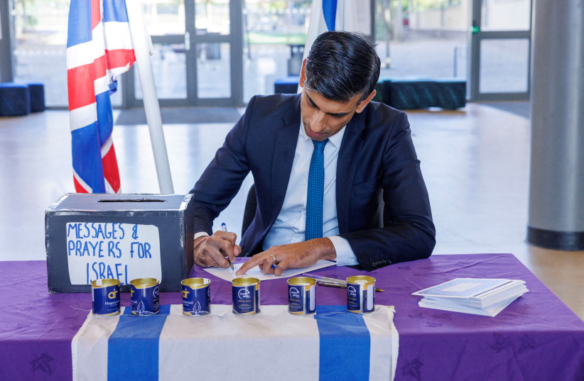 British Prime Minister Rishi Sunak signs messages and prayers for Israel at a Jewish school in London, Britain October 16, 2023 (credit: Jonathan Buckmaster/Pool via REUTERS)