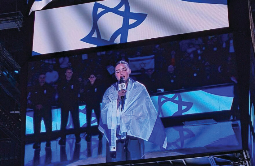  DRAPED IN THE Israeli flag, Noa Kirel performs ‘Hatikvah’ at Barclays Center before the NBA’s Brooklyn Nets played Maccabi Ra’anana last week. (credit: Am Israel Chai)