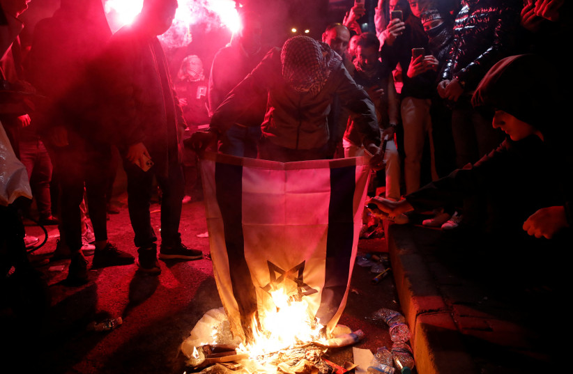  Pro-Palestinian demonstrators set an Israeli flag on fire during a protest near the Israeli Consulate as the conflict between Israel and Hamas continues, in Istanbul, Turkey October 18, 2023 (credit: REUTERS/DILARA SENKAYA)