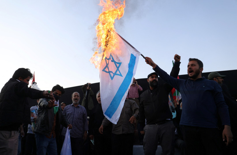   Protesters burn the Israeli flag during an anti-Israel protest in Tehran, Iran, October 18, 2023 (credit: MAJID ASGARIPOUR/WANA/REUTERS)