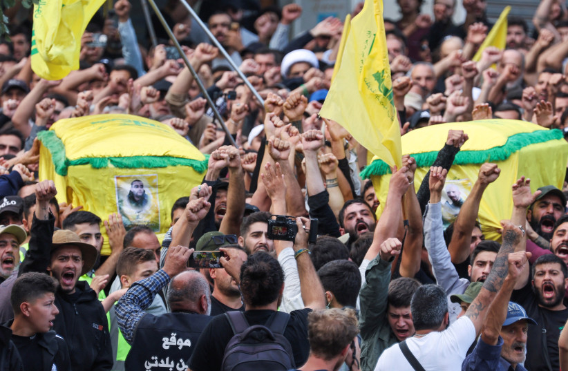 People gesture during the funeral of Hezbollah members Ali Ftouni and Hussam Ibrahim, who died during Israeli shelling on south Lebanon yesterday, in Khirbit Silm, southern Lebanon October 10, 2023.  (credit: MOHAMED AZAKIR/REUTERS)