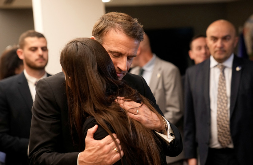 French President Emmanuel Macron hugs a woman as he meets Israeli-French nationals who have lost loved ones, as well as families of hostages, at the Ben Gurion airport, Tuesday, Oct. 24, 2023 in Tel Aviv. (Christophe Ena/Pool via REUTERS)