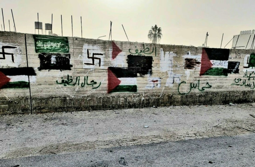  Nazi flags and PLO graffiti adorn a wall in Huwara, West Bank, October 24, 2023 (credit: COURTESY OF THE SAMARIA REGIONAL COUNCIL.)