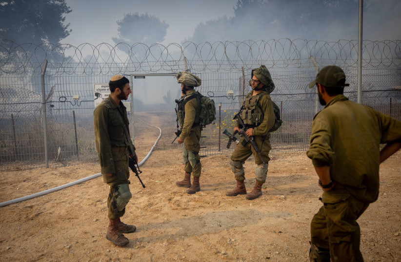  Israeli soldiers look at a fire caused by a rocket fired from the Gaza Strip at a forest near the border with the Gaza Strip, southern Israel, October 24, 2023. (credit: YONATAN SINDEL/FLASH90)