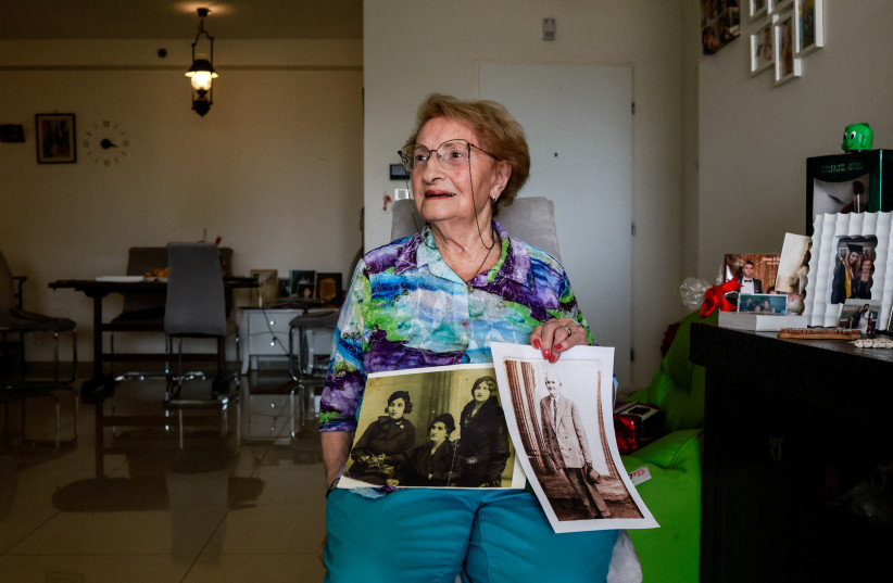 Holocaust survivor, Sarina Blumenfeld, 89, who endures flashbacks from the horrors of her past and now struggles to process the carnage following a deadly infiltration by Hamas gunmen, shows black and white photos during an interview with Reuters in her home in Ashdod, southern Israel, October 23