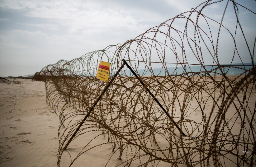  A barbed wire fence is seen on Zikim beach, in southern Israel near the border with Northern Gaza Strip, on April 5, 2016 (credit: CORINNA KERN/FLASH90)
