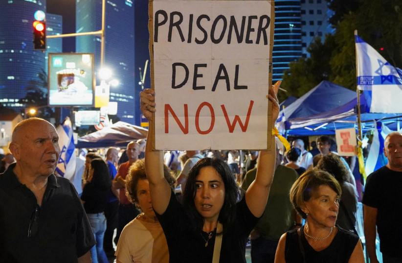 A woman holds a placard during a demonstration to show support and solidarity with the families of hostages who are being held in Gaza, amid the ongoing conflict between Israel and Hamas, in Tel Aviv, Israel, October 21, 2023.
