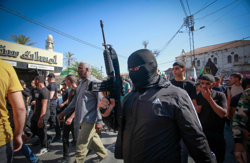 Palestinian mourners and gunmen attend the funeral of a three Palestinians who were killed in an Israeli airstrike, in the West Bank city of Jenin, October 25, 2023