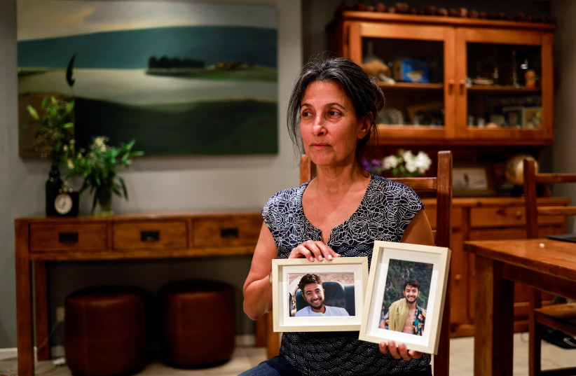  Rachel Goldberg, U.S.-Israeli mother of Hersh Goldberg Polin, which was taken hostage by Hamas militants into the Gaza Strip while attending a music festival in south Israel, holds photos of her son in their home in Jerusalem October 17, 2023 (credit: REUTERS/AMMAR AWAD)