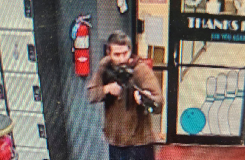  A man identified as a suspect by police points what appears to be a semiautomatic rifle, in Lewiston, Maine, U.S., October 25, 2023 (credit: Androscoggin County Sheriff's Office via Facebook/Handout via REUTERS)