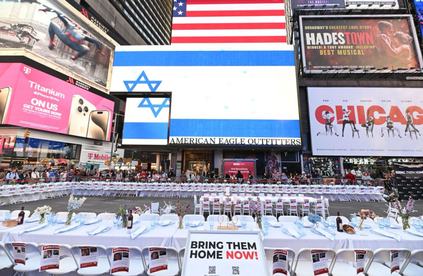  Crowds view a festive Shabbat (Sabbath) table set for 224 people sat in Times Square, New York, Thursday, in an installation by the Israeli-American Council (IAC) to symbolize the plight of the hostages held captive by the terror group Hamas. (credit: Noam Galai for IAC.)
