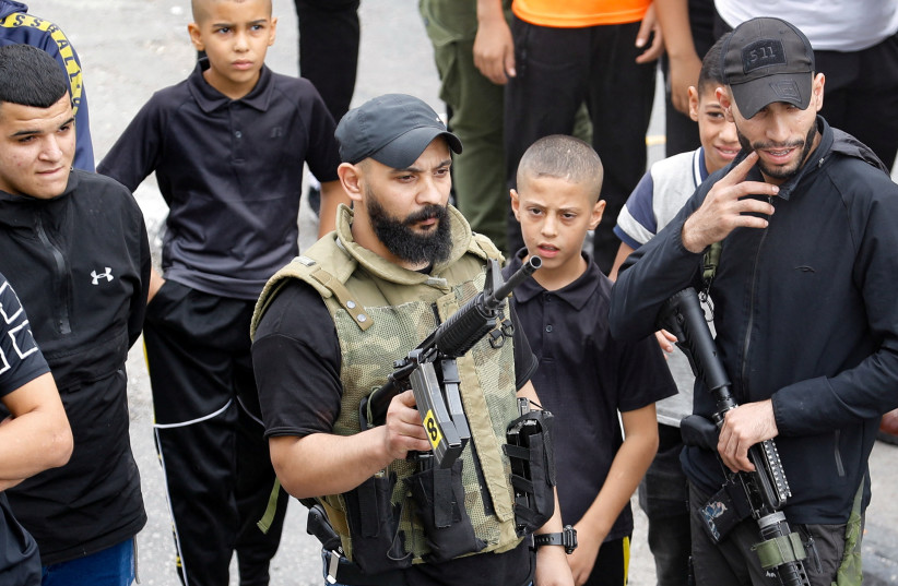  Gunmen stand among boys during the funeral of Palestinian Naem Farran who was killed in an Israeli raid, in Askar camp near Nablus, in the West Bank October 29, 2023. (credit: REUTERS/RANEEN SAWAFTA)