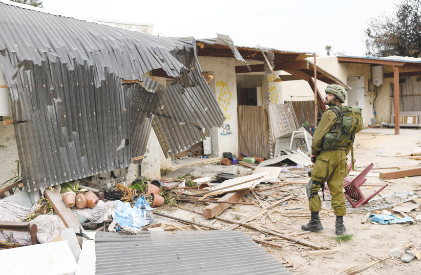  An IDF soldier looks at the destruction in Kibbutz Kfar Aza, one of the hardest-hit communities in the October 7 onslaught by Hamas. (credit: GILI YAARI/FLASH90)