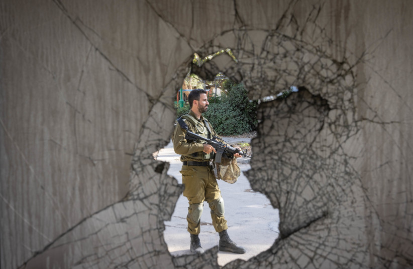 Israeli soldier around the destruction caused by Hamas terrorists in Kibbutz Nir Oz on October 7, 2023, near the Israeli-Gaza border, in southern Israel, October 30, 2023 (Chaim Goldberg/Flash90)