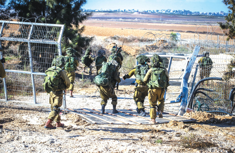  IDF SOLDIERS take up a position at the fence of Kibbutz Kfar Aza, near the Israel-Gaza border. (credit: OREN BEN HAKOON/FLASH90)