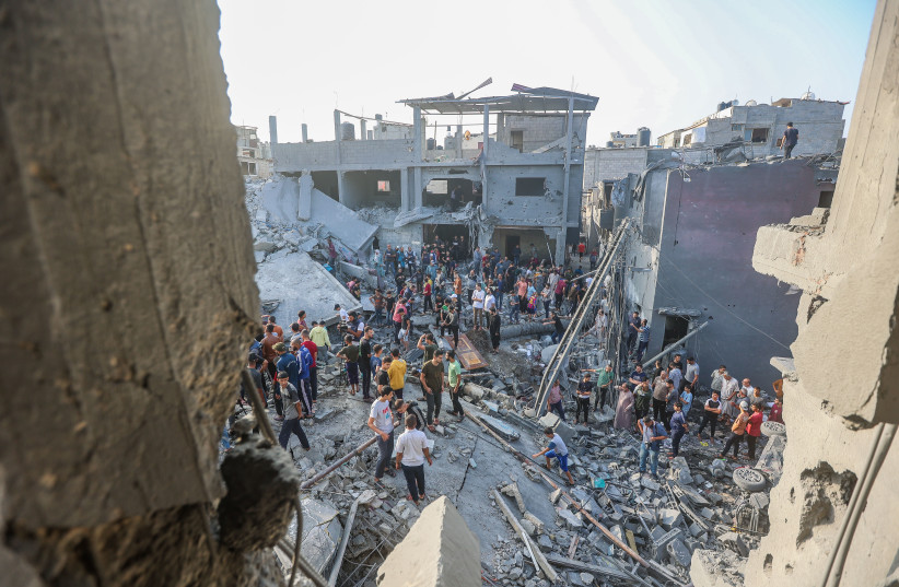 Palestinos frente a los escombros de un edificio destruido tras un ataque aéreo israelíí en el centro de la Franja de Gaza, el 5 de noviembre de 2023 (crédito: ATIA MOHAMMED/FLASH90)