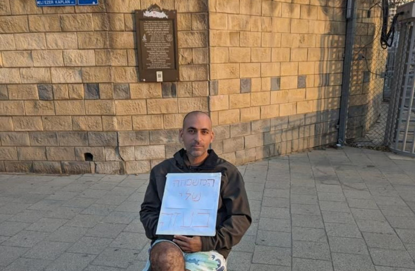 Avihai Brodutch, whose wife and three children were abducted by Hamas militants on October 7 from their home in Kibbutz Kfar Aza, demonstrates outside Israel's Defence Ministry on October 14, 2023, with a sign in Hebrew reading ?My family is in Gaza?, in Tel Aviv, Israel, in this handout photo. (credit: Avihai Brodutch/Handout via REUTERS)
