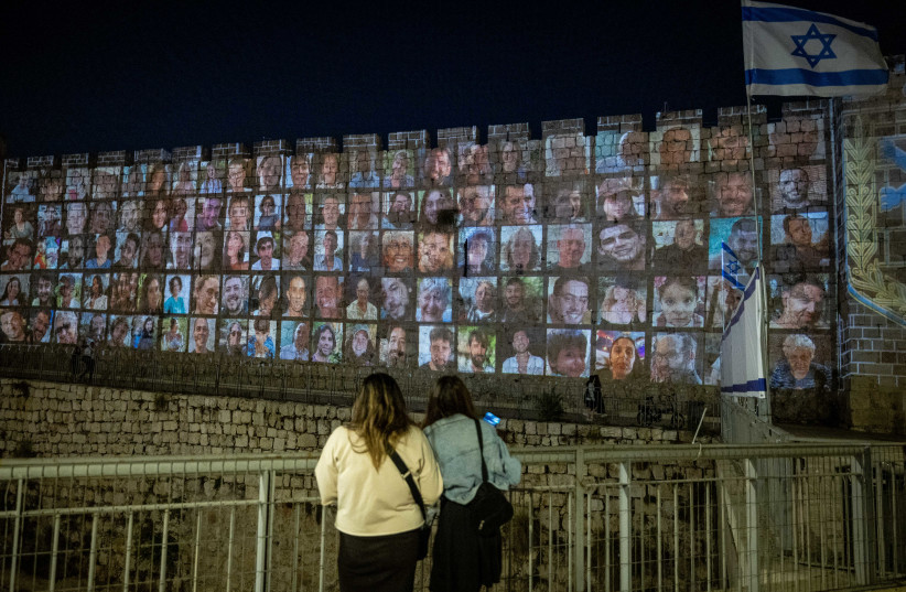  Pictures of Israelis abducted by Hamas terrorists in Gaza are screened on the walls of Jerusalem's Old City, on November 6, 2023. (credit: YONATAN SINDEL/FLASH90)