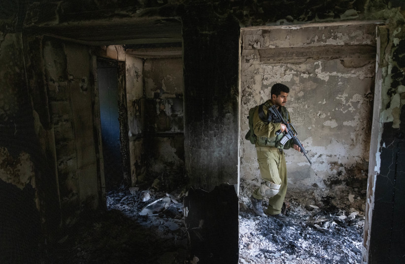  Israeli soldier around the destruction caused by Hamas terrorists in Kibbutz Nir Oz on October 7, 2023, near the Israeli-Gaza border, in southern Israel, October 30, 2023. (credit: Chaim Goldberg/Flash90)