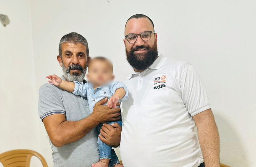  Ariel Pachima (right) with Hamed and his infant son. (credit: COURTESY UNITED HATZALAH)