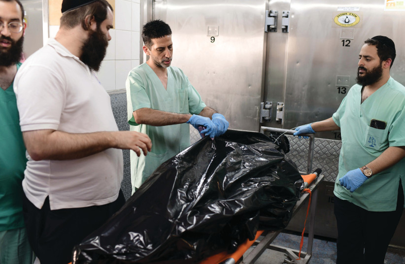  WORKING ON a body at Abu Kabir Forensic Institute, Oct. 18.  (credit: TOMER NEUBERG/FLASH90)