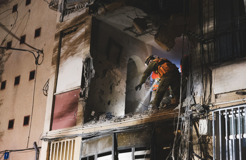  Israeli Home Front Command personnel clear an apartment that was struck by a Hamas rocket. (credit: IDF SPOKESPERSON'S UNIT)